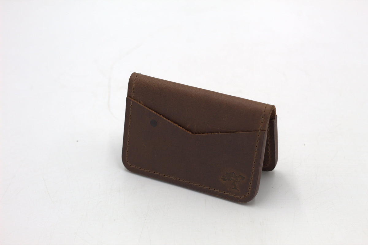 A black leather wallet with a front flap and metal accents, isolated on a white background.
